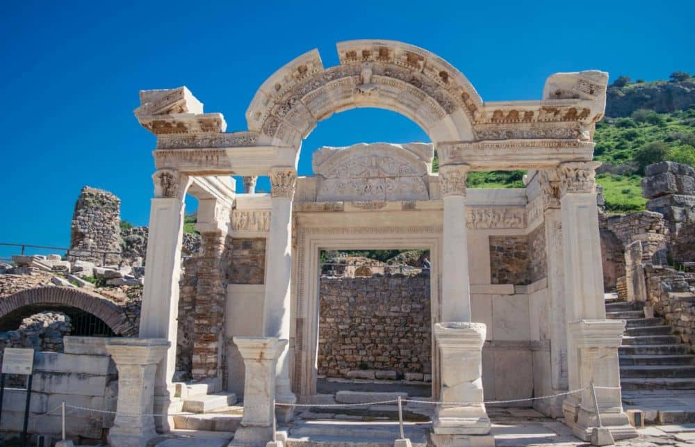 A ruin of a square temple at Ephesus: pillars support a carved archway.