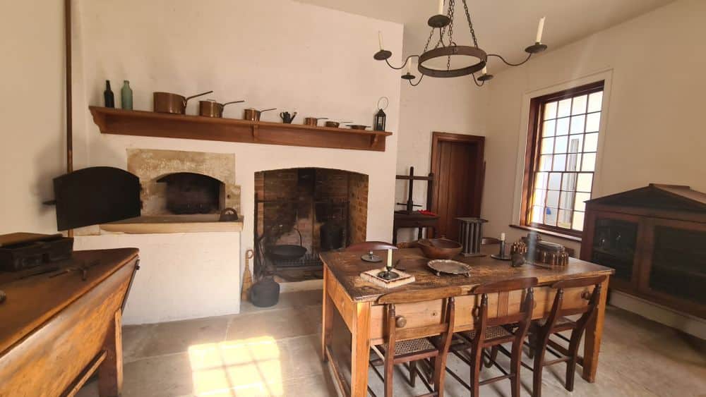 Kitchen view: a simple wooden table with chairs around it; behind that, a fireplace - in Old Government House, one of the Australian Convict Sites.