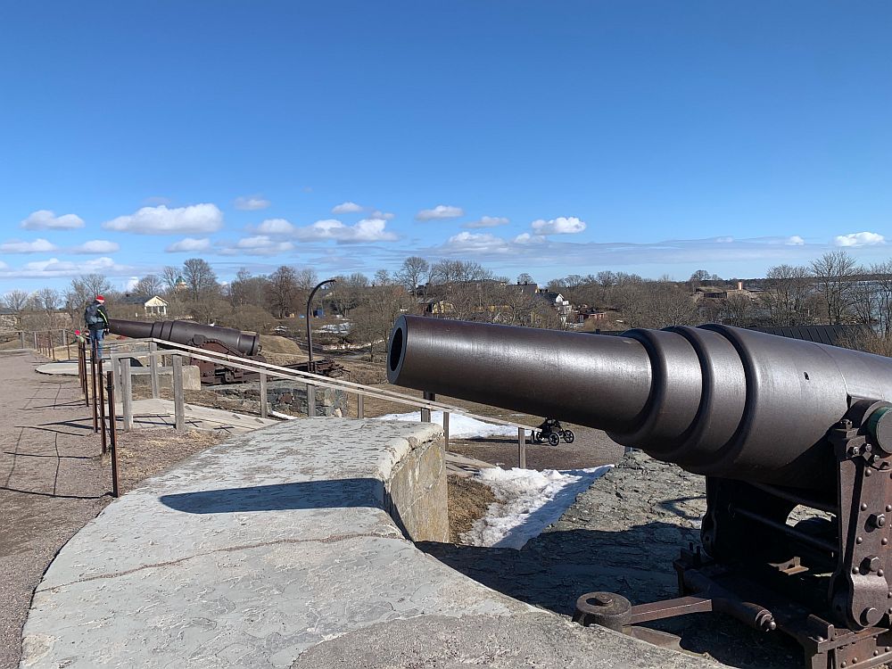 Sighting along a fortress wall, a cannon stands pointed over the wall.