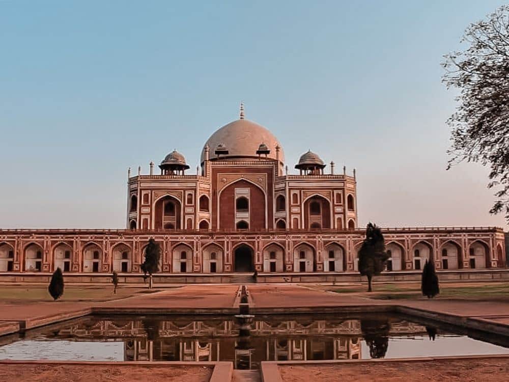 View of Humayuns tomb seen from across a piece of the garden with a pond.