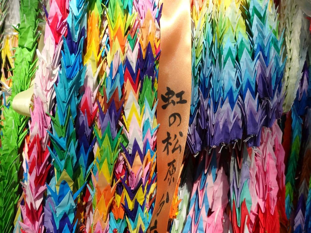 A bundle of long strings of colorful paper, looking like garlands rather than individual paper cranes.