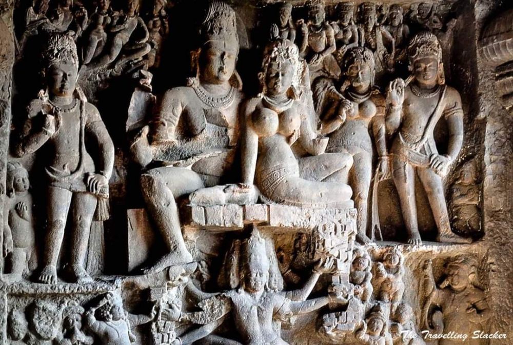 A very detailed bas-relief depiction in Ellora Caves of human-like figures, with a man and a woman prominent in the center.