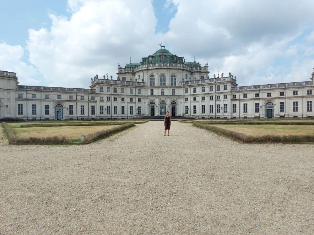 Seen across a broad flat area, a large palace, white and symmetrical.