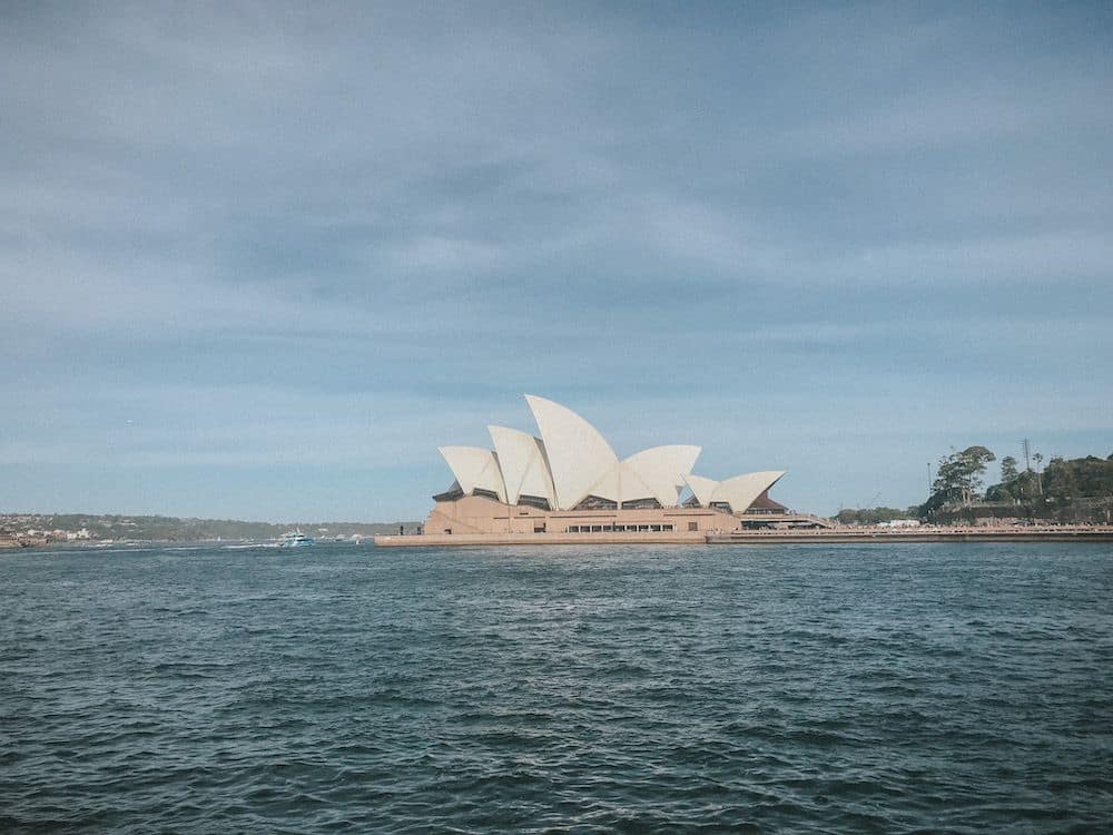 A distant view of Sydney Opera House, with its white rounded shapes.