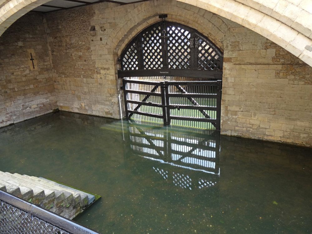 A gate set into a stone wall - the bottom half under water.