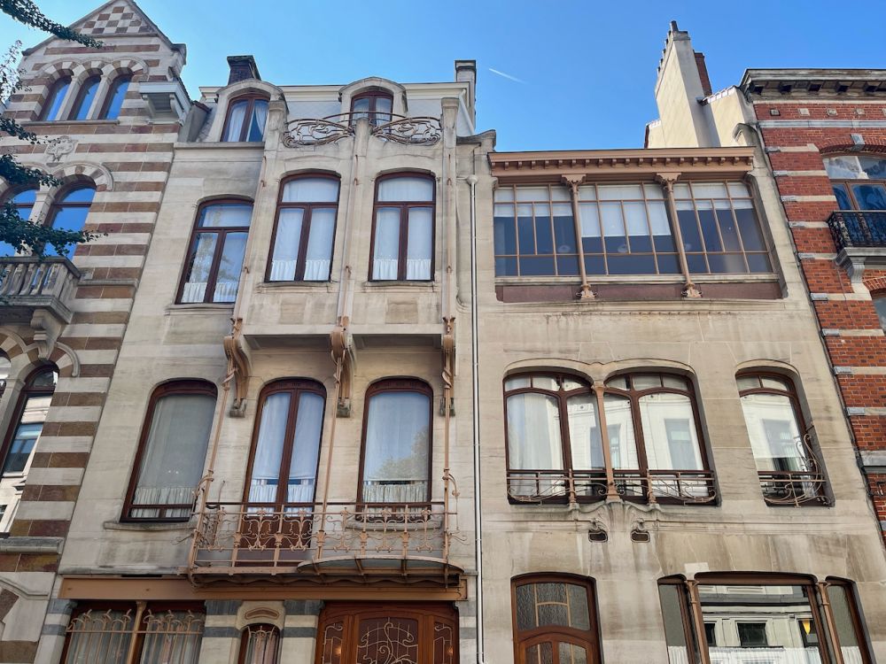 Looking up at the facade of the Horta museum: only about 4 stories tall, with slightly squared arched windows.