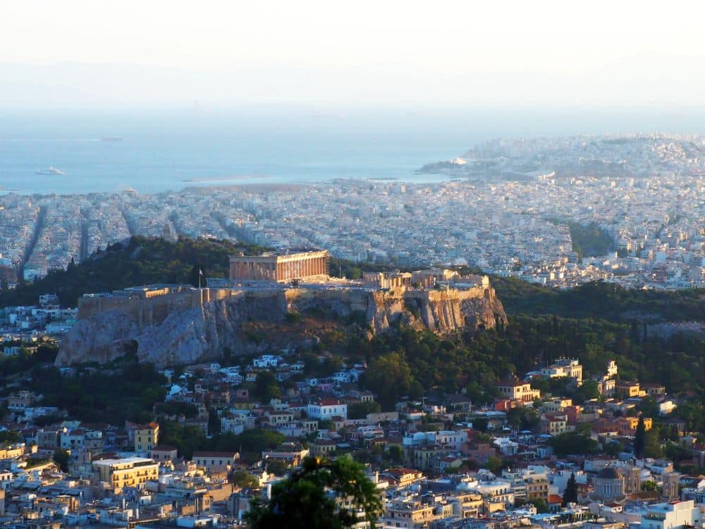 View of the Acropolis, the hill it stands on, and the city around it.