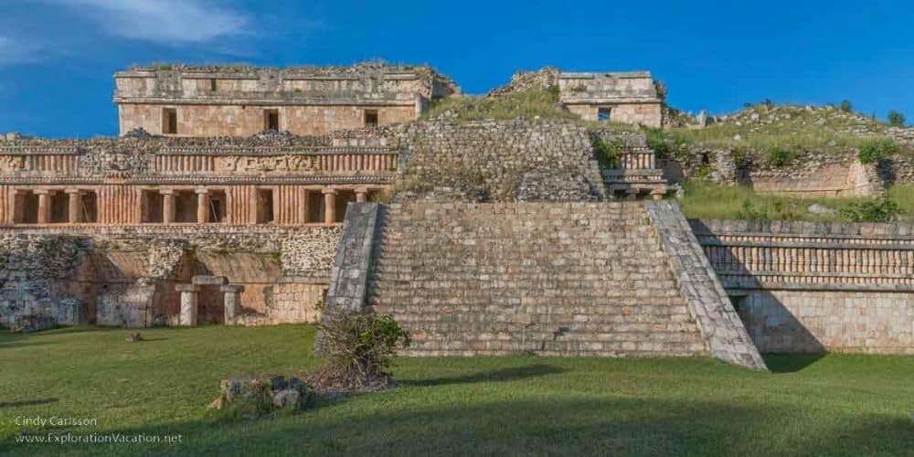 A large stone structure on a high stone platform with a wide stairway leading up to it.