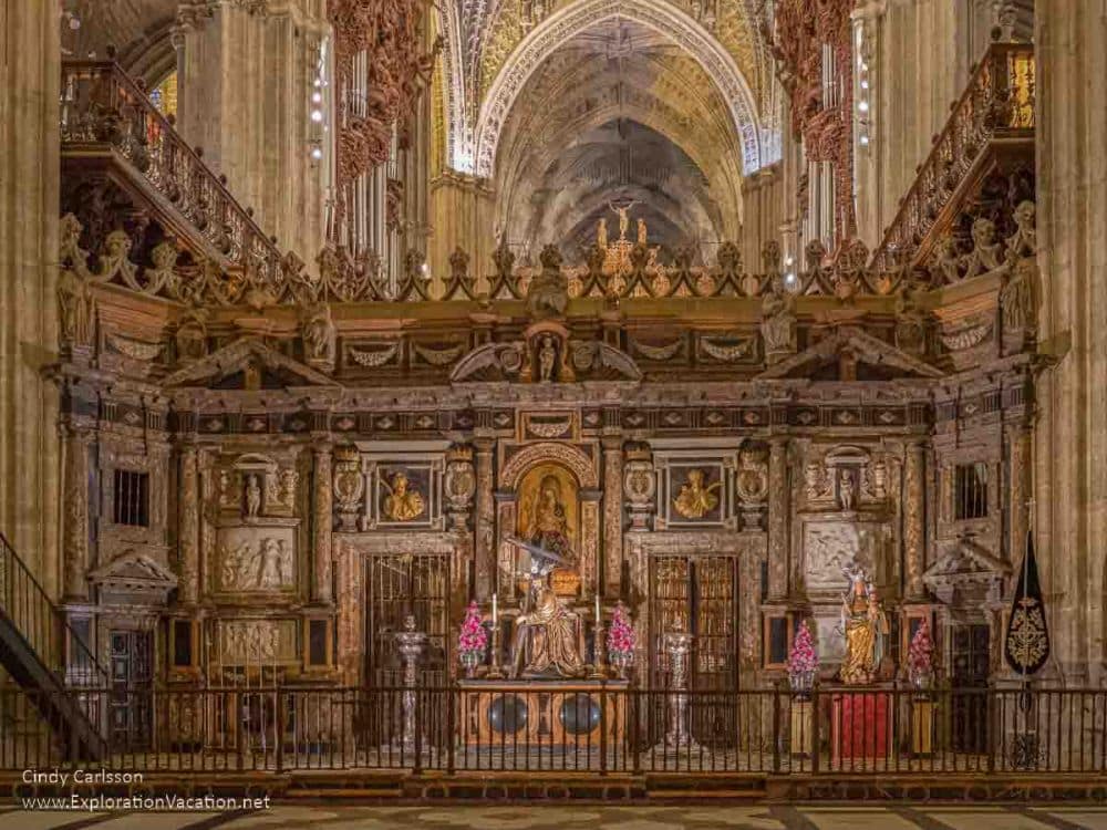 An extremely ornate choir carved in wood with inset paintings and all sorts of detail. The arches of the cathedral are visible behind, giving a sense of how huge the cathedral is.