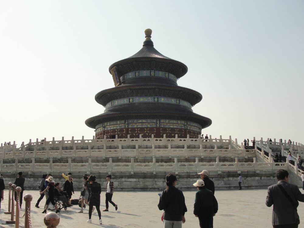 A large round pagoda with three roofs and concentric walls around it, each higher than the one outside it.