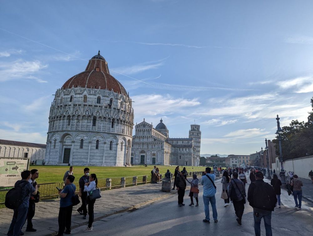 People in the foreground with, in the background, the domed Baptistery and cathedral.