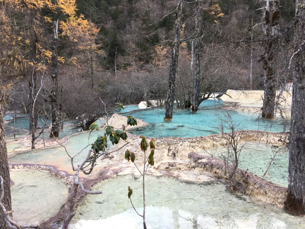 Several travertine ponds in shades of blue.