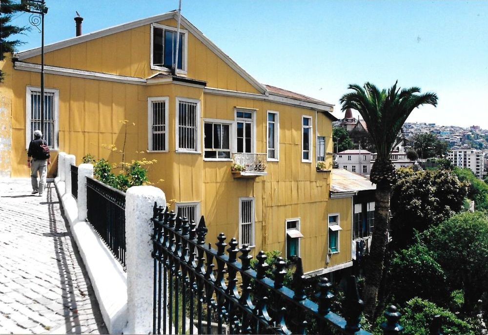 A bright yellow house on a sloping hill.