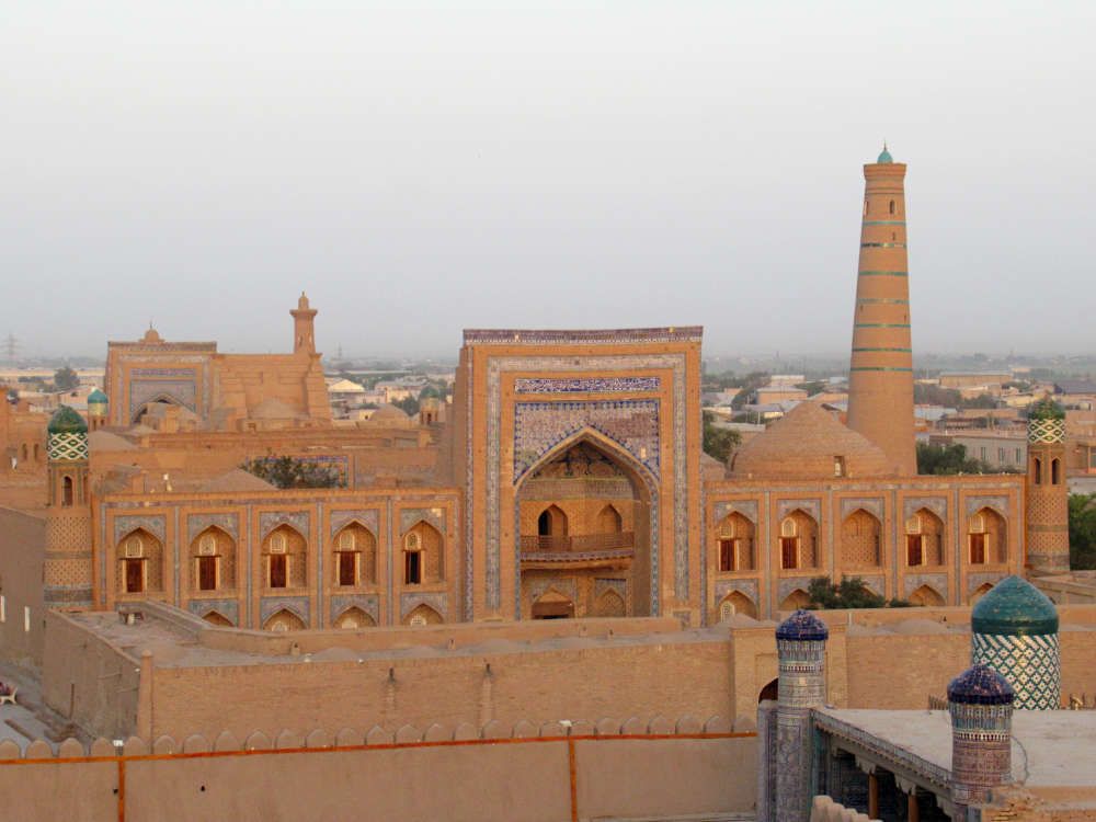 A large mosque with a very tall minaret and a huge rectangular archway.