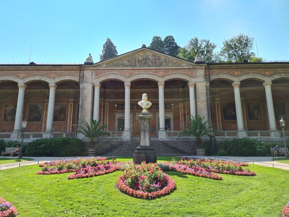 View of the center of the building: a portico held up by narrow columns in a classical style.