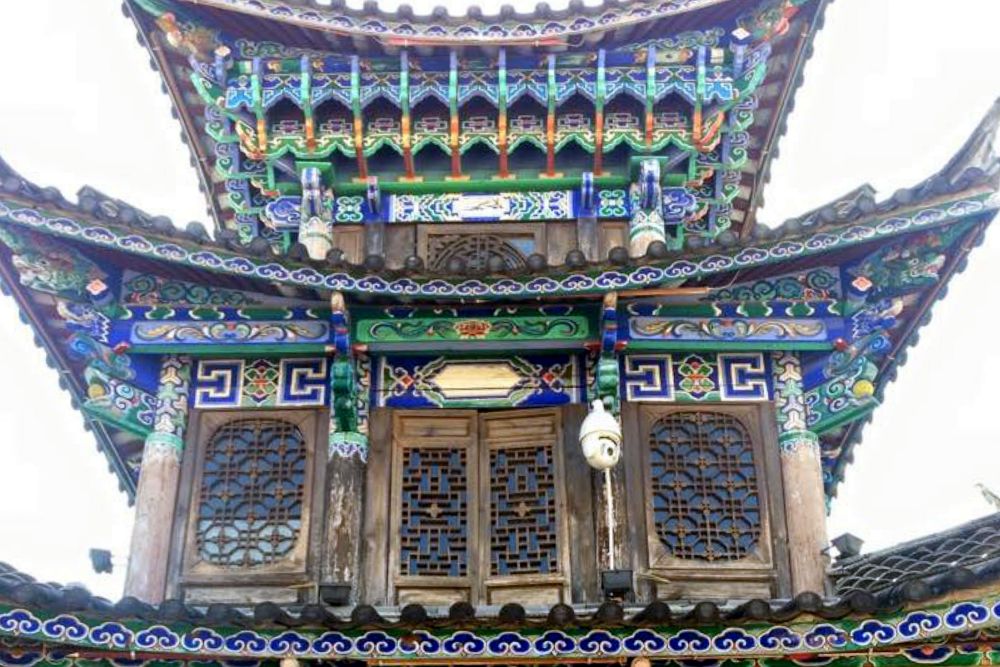 The upper stories of a house: the top smaller than the one under it. All of it is very ornately decorated around and between windows and curved roof lines.