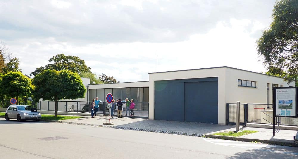 Tugendhat Villa is a boxy house, single-story, with a flat roof and a brown double garage door.