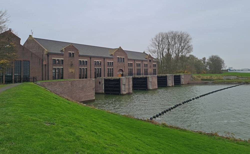 View of the lakeside side of the Woudagemaal: a 2-story building built on a platform of sorts spanning the water.