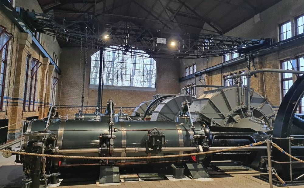 A very large room with brick walls, with a huge arched window in the far wall. Large machines fill the hall - the steam pump.
