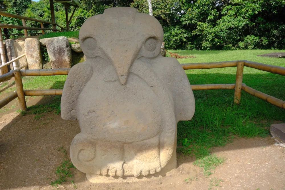 A large stone statue of a almost cartoon-like standing bird.