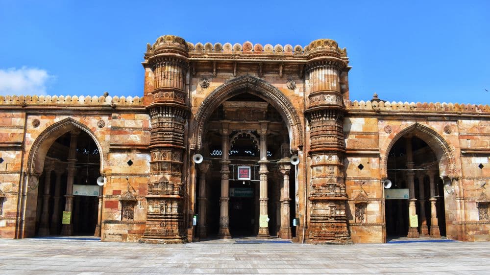 The entranceway in the dille is arched and quite grand, with pillars inside it. The building extends out on both sides, lower than the central archway, with smaller arches along its length.