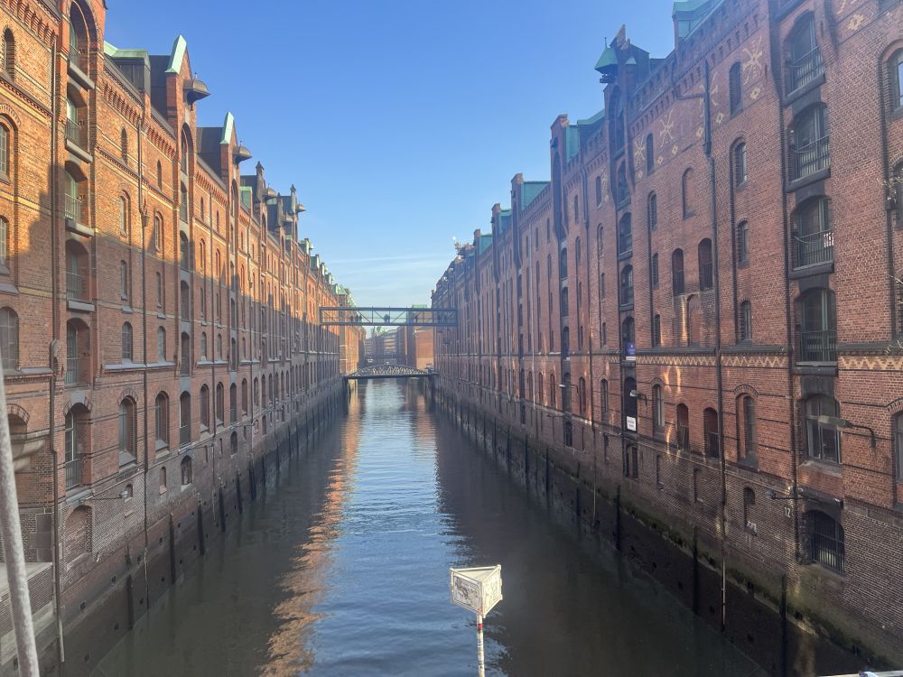 Looking down a canal with large red-brick warehouses lining both sides.