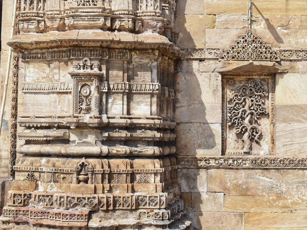 A detail showing carved images, including an ornate tree or vine image.