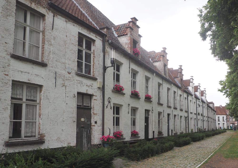 A row of 3-story houses painted white.