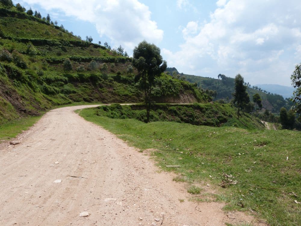 A dirt road curving ahead along a hill.
