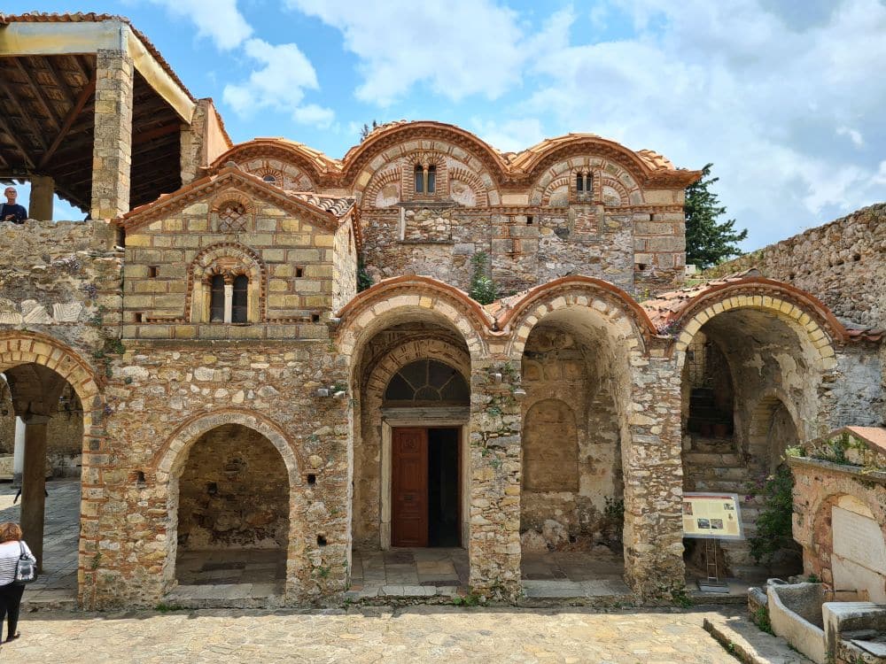 Front of a church - 2 storeys, arches along the edge of the roof as well as above the entrances.