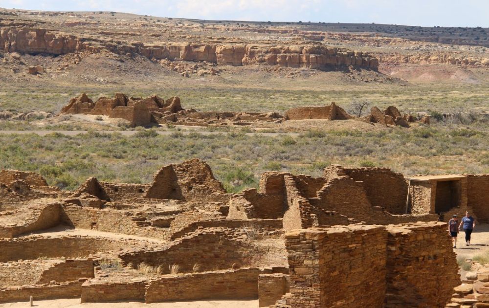 A big landscape with ruined walls in the foreground and a mesa in the background.