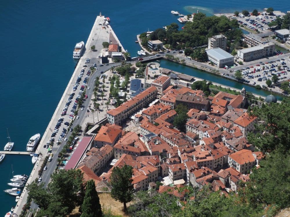 A point of land and a cluster of red-roofed buildings, seen from above.