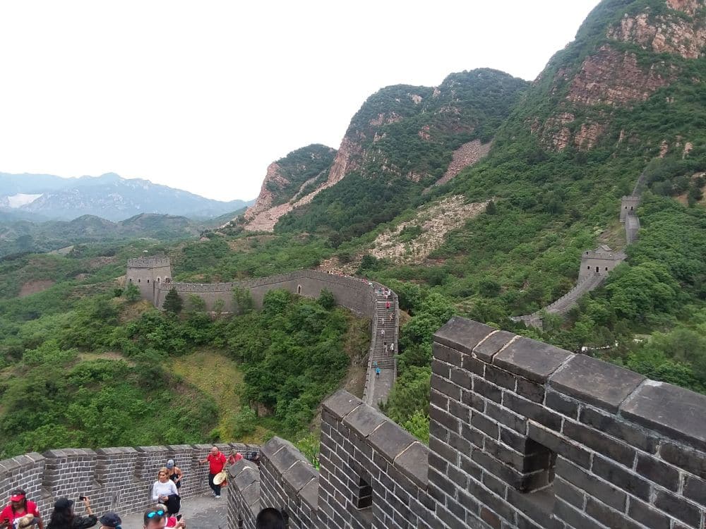 A view along a section of the wall from one watchtower toward another along a row of mountain peaks.