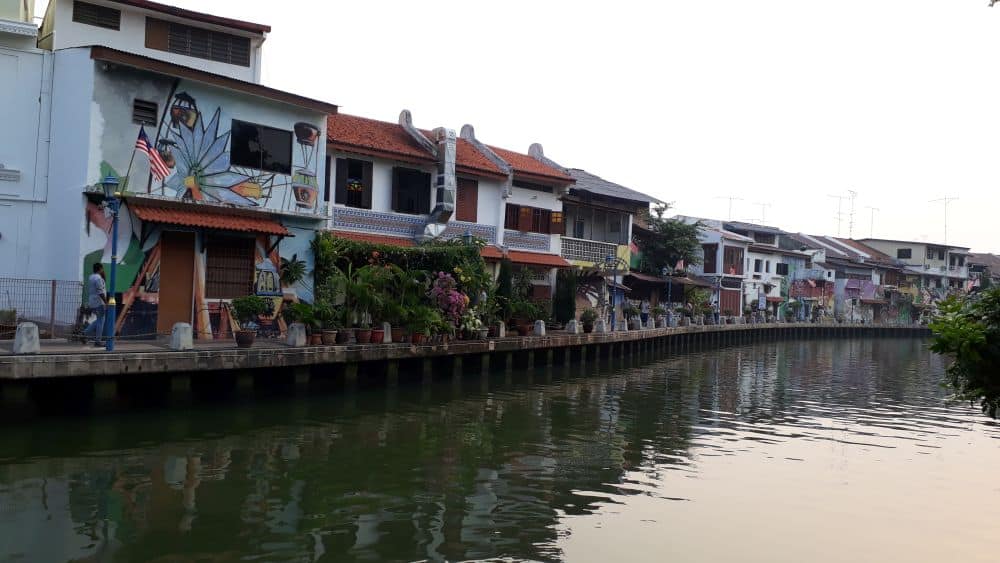 View down a river with houses right along its edge.