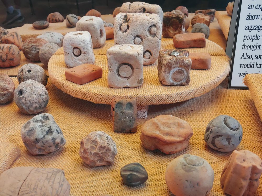 Small stone balls and cubes, some carved with circular figures. 