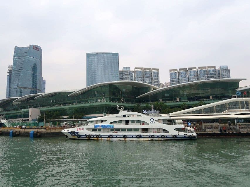 The cruise ship terminal is a wide modern building with rounded roofs and glass walls.