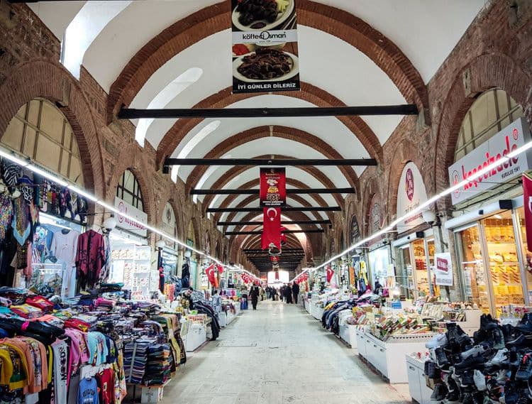 View down a long arched hall lined with shop stalls.
