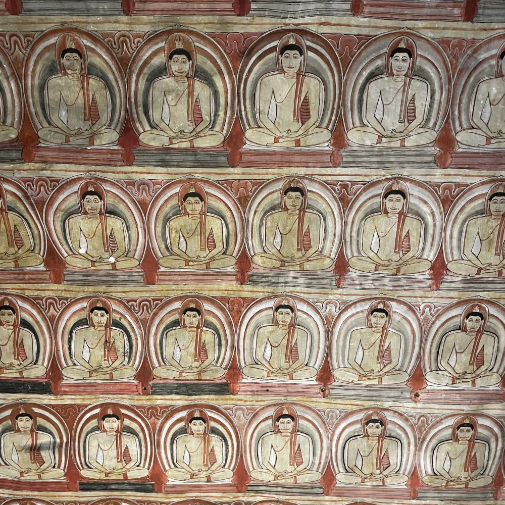 A section of fresco with four rows of a repeating image of a seated buddha.