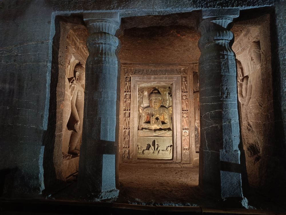 Image: an alcove with two pillars at its entrance: inside 3 ornated bas-reliefs are visible, one on each of the three sides.