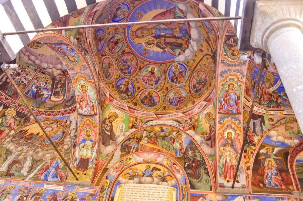 Brightly painted frescos of biblical figures on a ceiling.