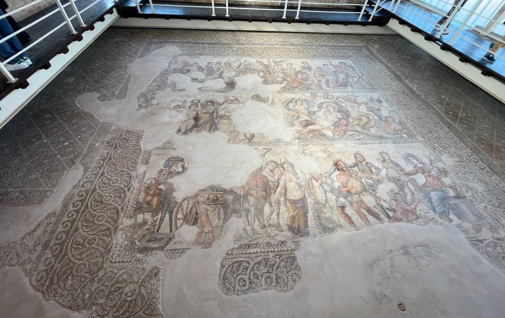 A large floor mosaic with scenes of humans.