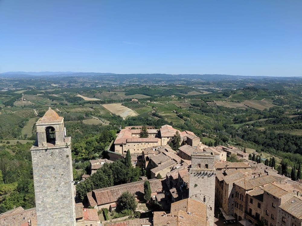View from the tower showing 2 of the towers and the cluster of buildings of the historic center, with green agricultural areas beyond the town.