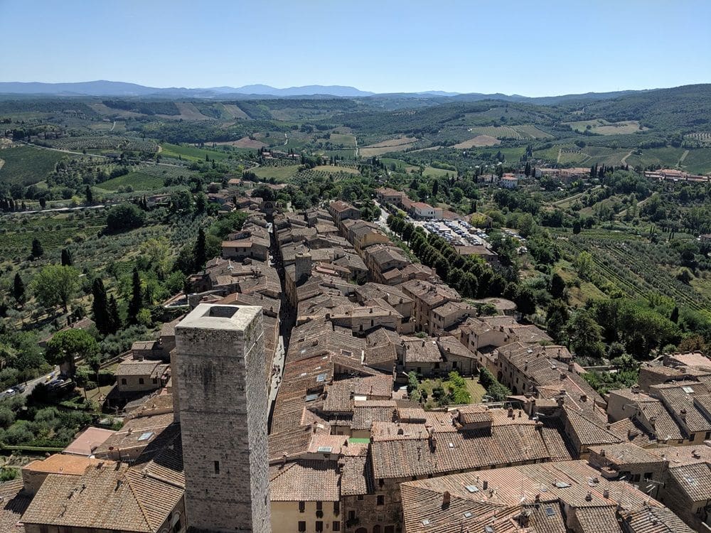 A view from the tower showing the cluster of buildings in San Gimignano and the agricultural areas around it.