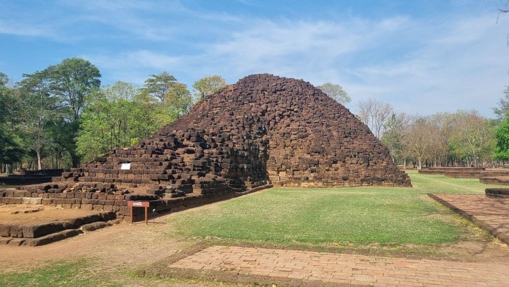 A pyramid-shaped structure of dark reddish stones.