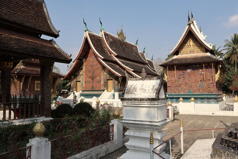 Several temple buildings with typical Laotian curved peaked roofs and decorative fronts.