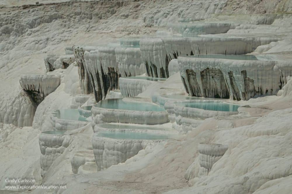 A closer view of the white terraces shows several small pools of blue water.
