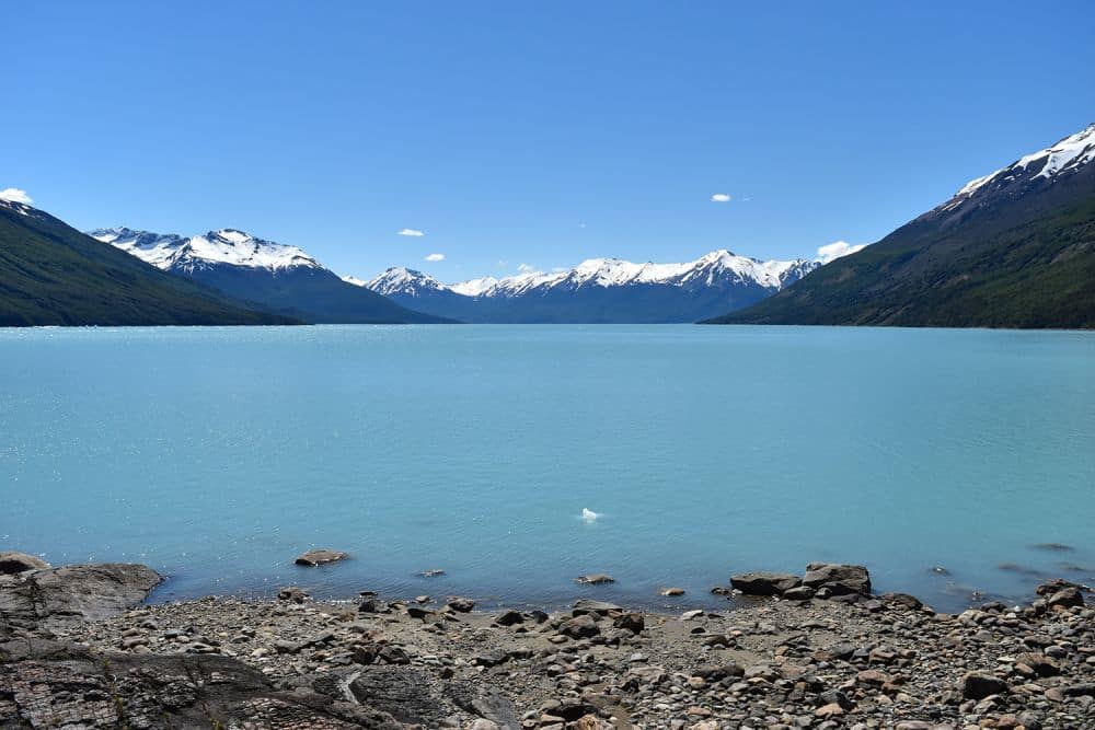 A huge blue lake with snow-covered mountains visible on the far side.