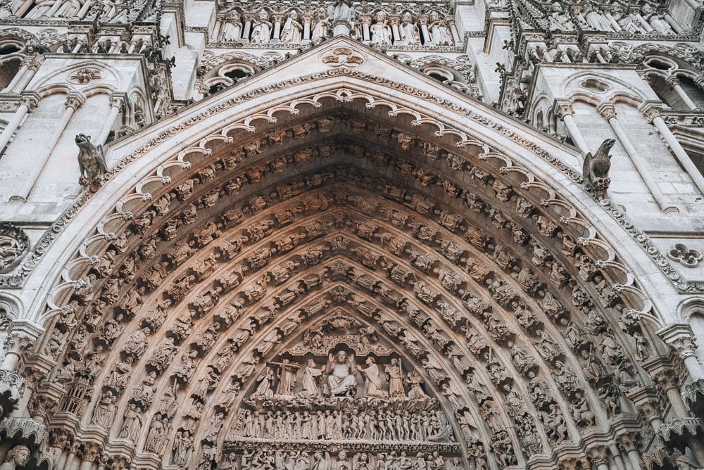 The archway over the main entrance to Amiens Cathedral: gothic arch with lots of figures of saints.