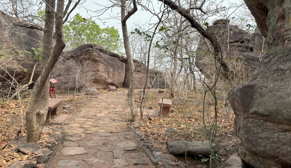 A cobbled path leads past some of the rock shelters of Bhimbetka - info boards along the path.