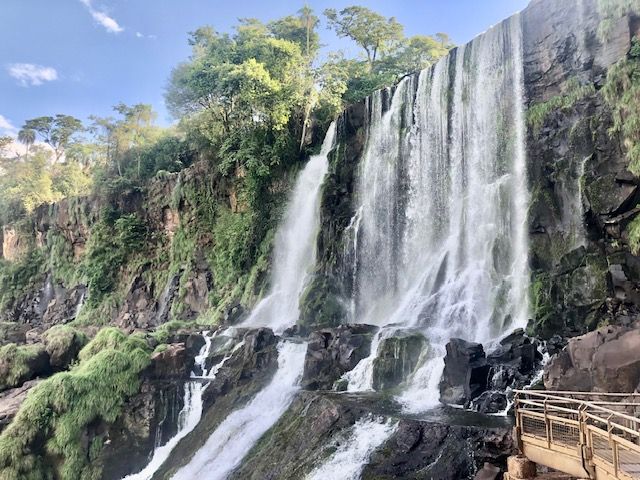 A row of small waterfalls flow over a cliff.